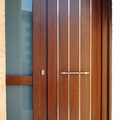 Puerta de exterior con listelos de acero inox.