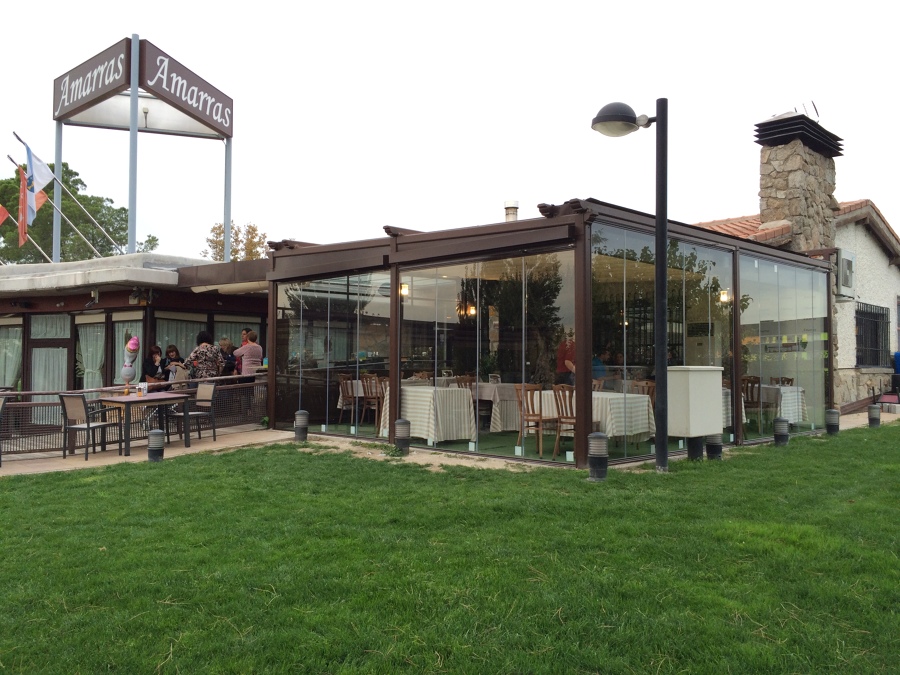 Cerramiento de terraza mediante pérgola de lona doble y cortinas de cristal