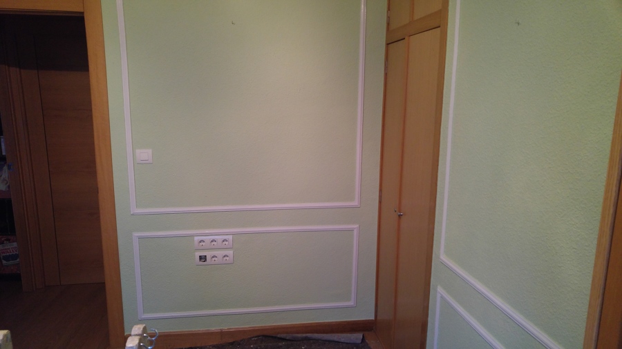 Sala de estar en color verde con moldura en blanco 