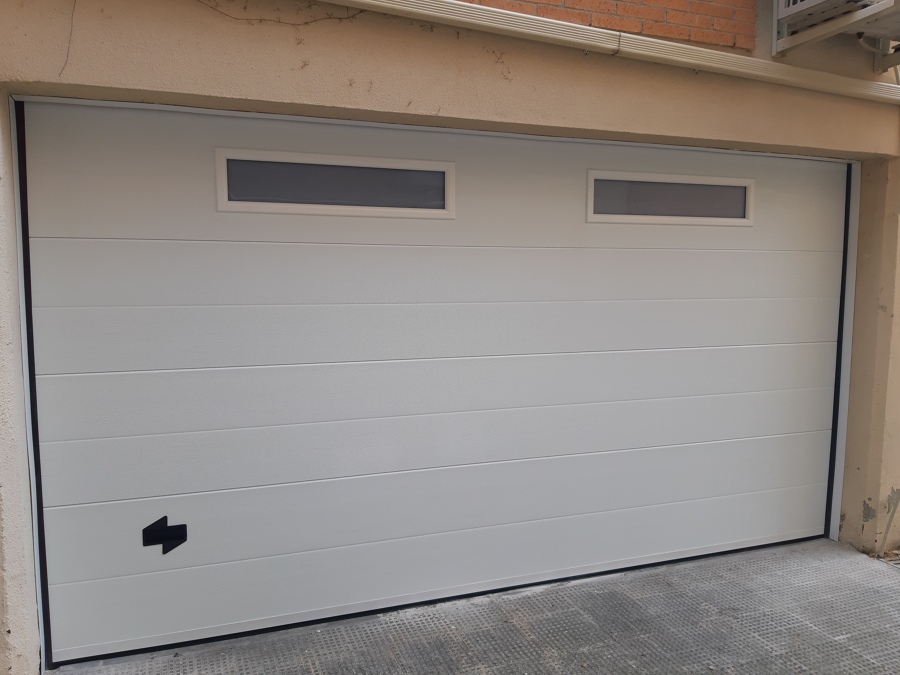 Puerta seccionable con ventanas tragaluz.