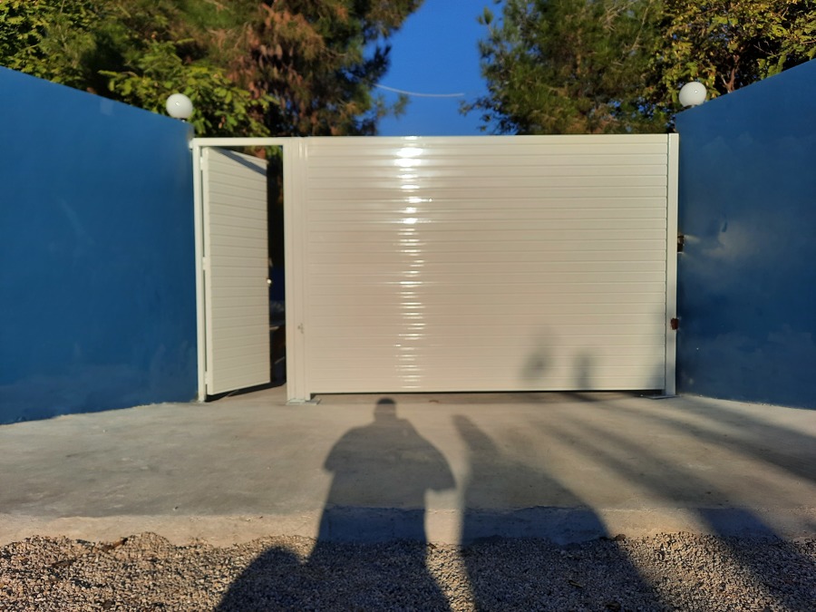 Puerta abatible motorizada y puerta peatonal en blanco