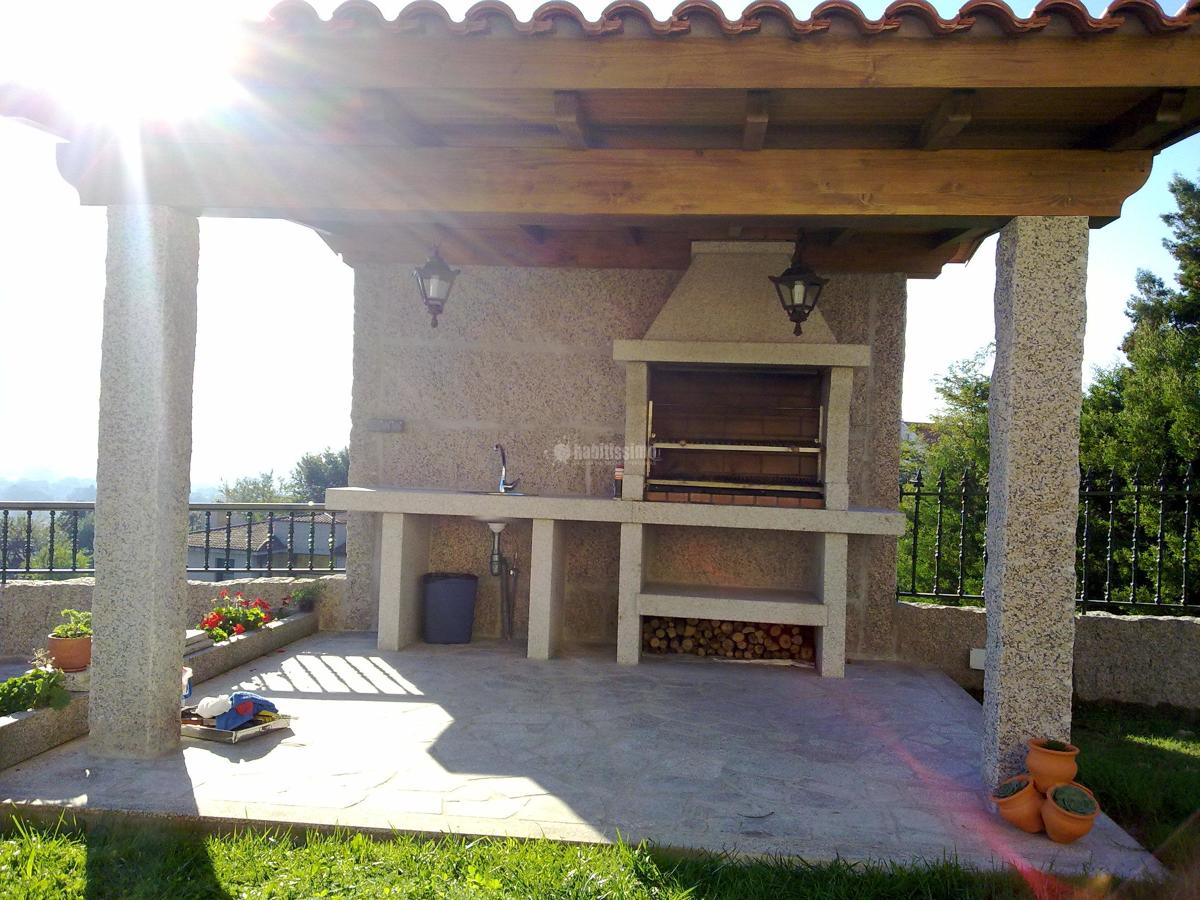 Construcción de garaje y barbacoa con estructura de madera y panel sandwich de madera.