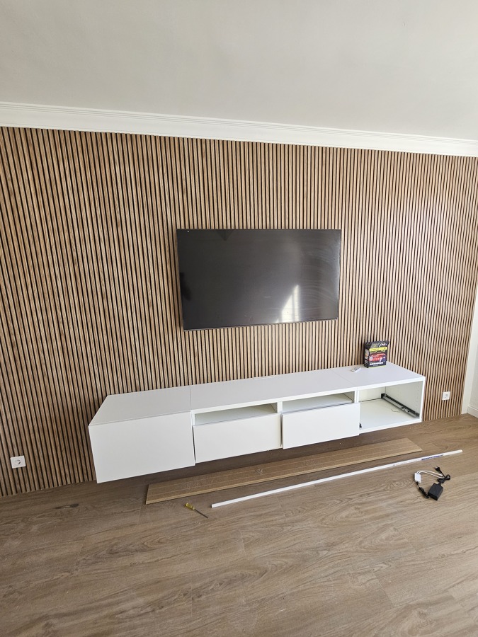Muro recubierto en madera decorativa para el televisor con mueble empotrado a pared con un toque elegante