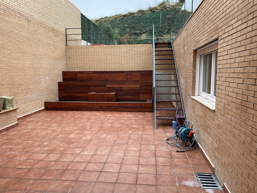 Patio con jardineras, suelo y escalera de forja
