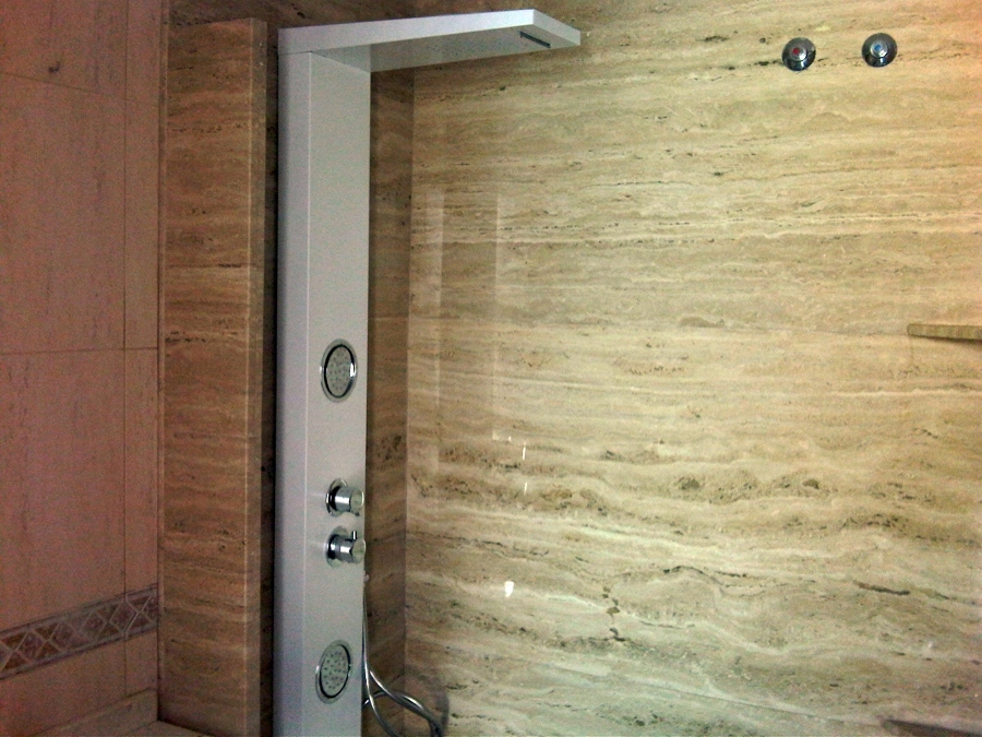 Baño aplacado de mármol tragavino.