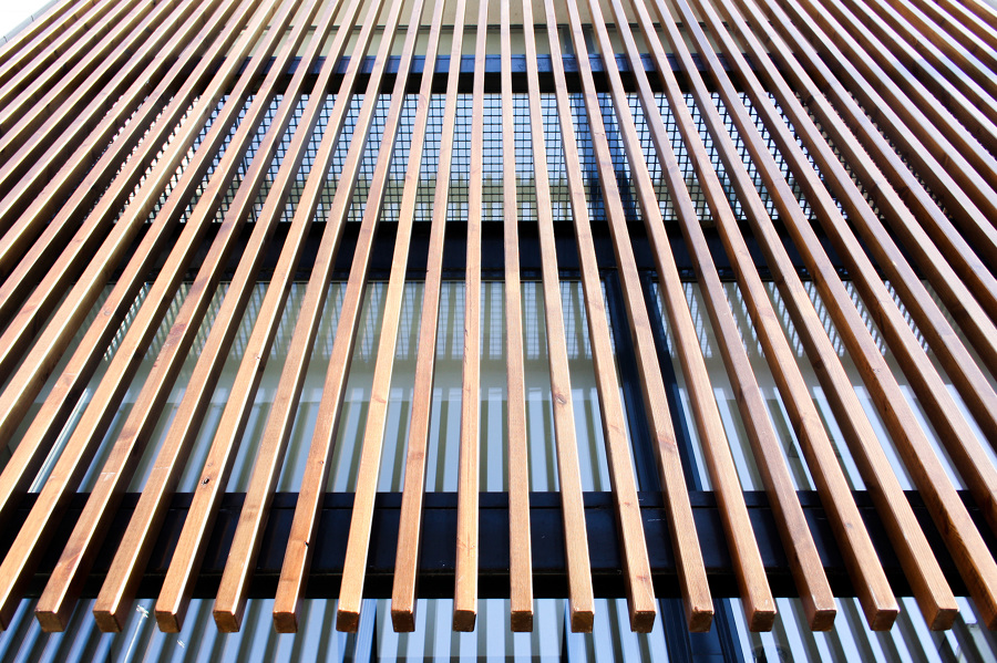 Fachada de vidrio con filtro solar de madera