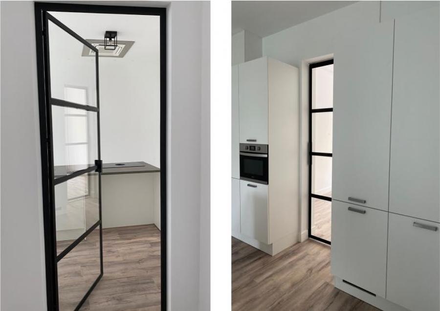 Puerta de perfilería metálica lacada en negro y vidrio.