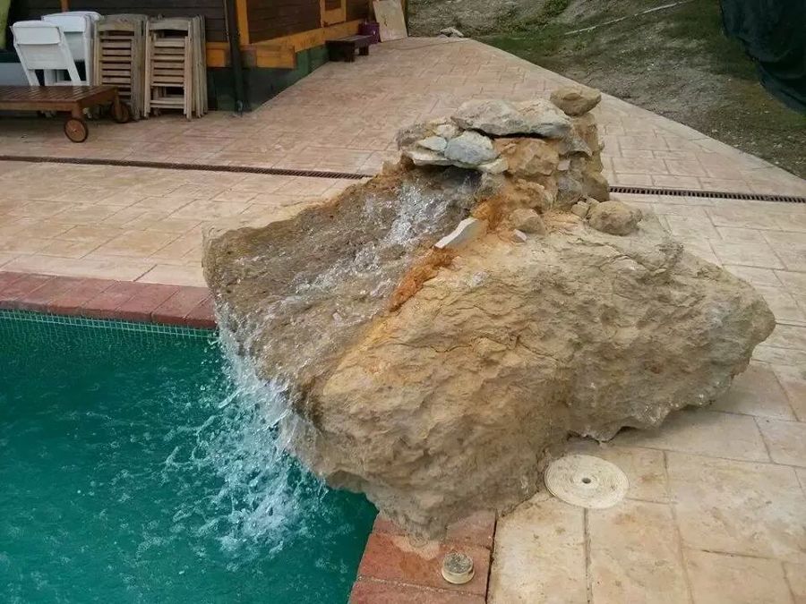 cascada sobre roca en piscina privada