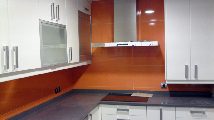 Cocina alicatada con azulejo naranja.