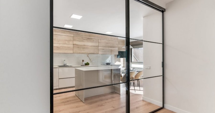 Separador de perfilería metálica lacada en negro y vidrio.