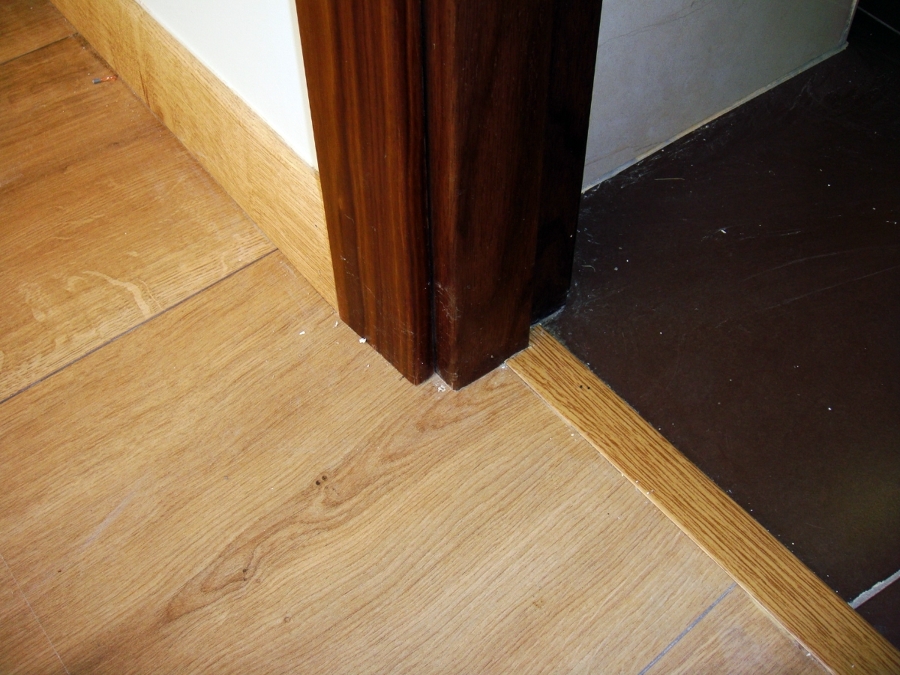 Detalle de tarima, marco de puerta y solado cerámico