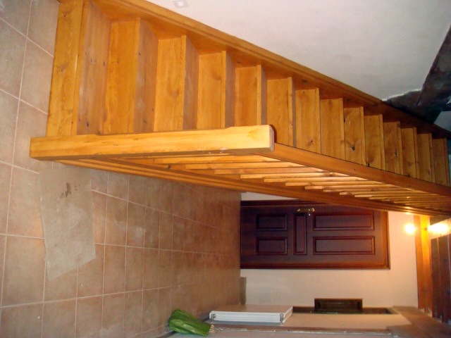 Detalle escalera de madera barnizada
