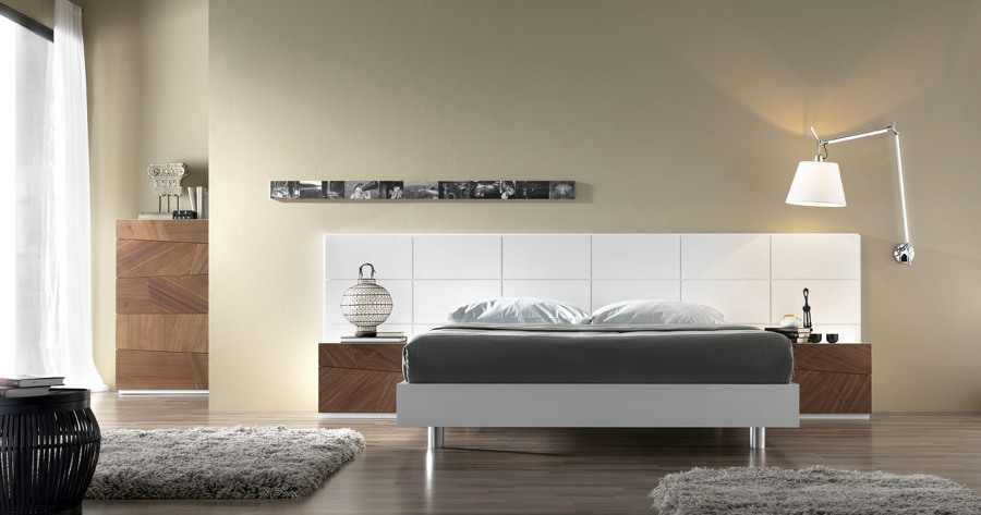 Dormitorio con cabecero panelado en laca blanca.