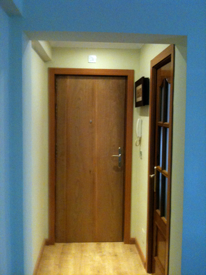 Entrada a vivienda con vista de la puerta de entrada recuperada y de la cocina.