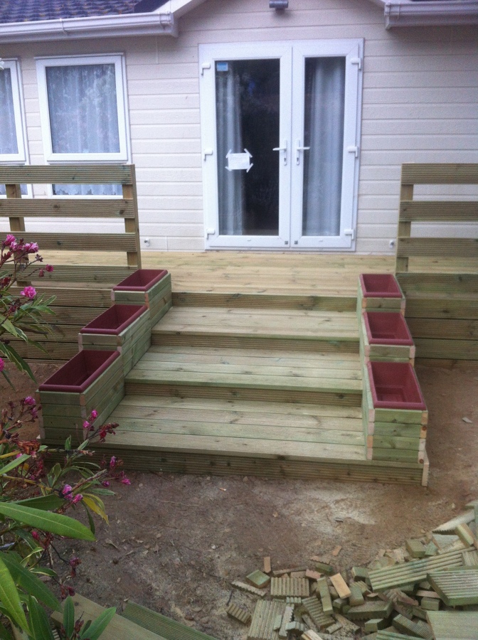 Escalera de acceso a terraza exterior de mobil homes con jardineras a medida