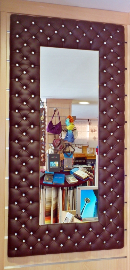 Espejo tapitado capitone con botones de cristal.