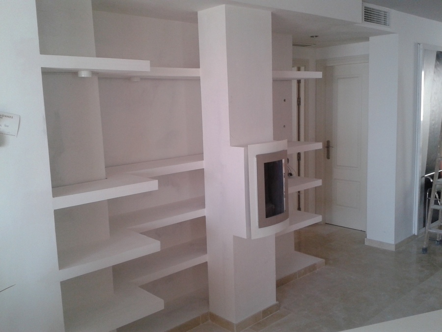 Estanterías con una chimenea en el centro  