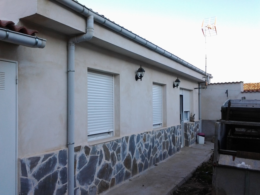 Fachada de piedra y cemento blanco