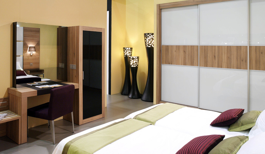 Habitación de hotel con armario, dormitorio y escritorio.