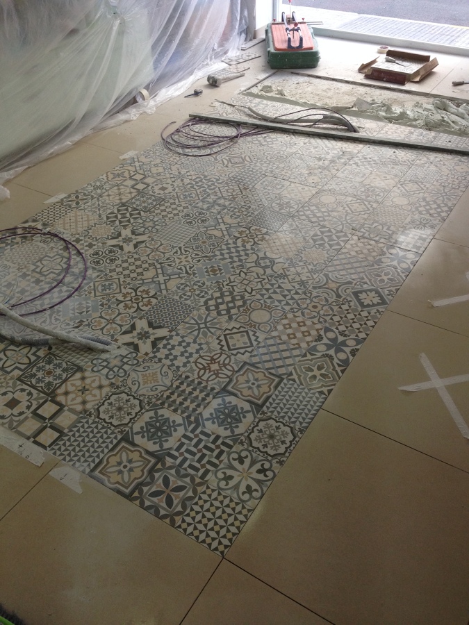 Reforma en una farmacia , ampliación al retirar un tabique y colocación de un suelo haciendo una alfombra para la zona de mostradores