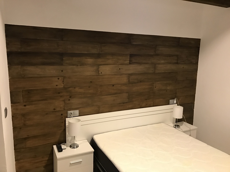 Habitación con cabezal de cama imitación madera