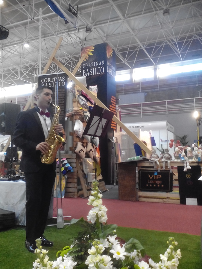 SAXOFONISTA FRENTE AL STAND DE CORTINAS BASILIO