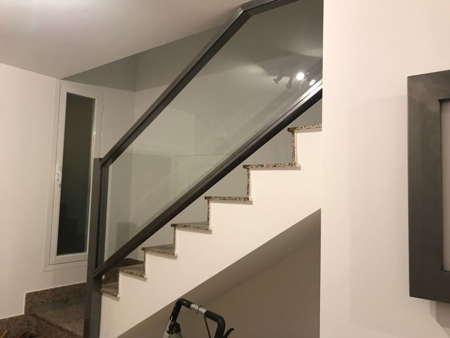 Barandilla de hierro pulido y cristal, barnizado al horno.