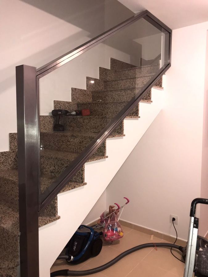 Barandilla de hierro pulido y cristal, barnizado al horno.