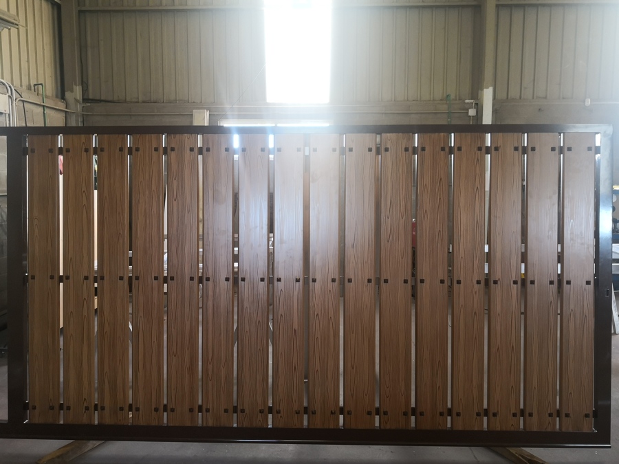 Portal corredera de aluminio soldado y lamas lacadas en color madera