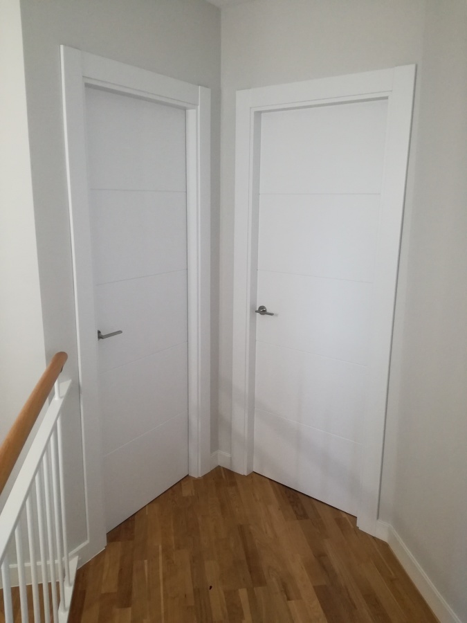 Puertas lacadas en blanco, suelo flotante de roble