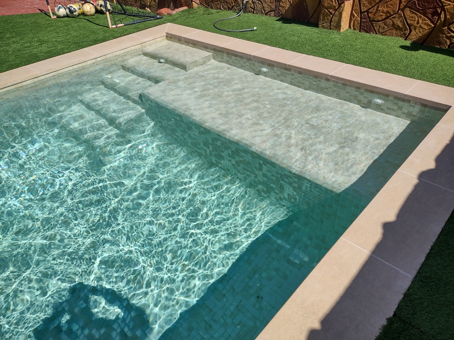 Piscina con coronación porcelánica beige y gresite Hisbalit Aqualuxe Mallorca en formato 4x4.
