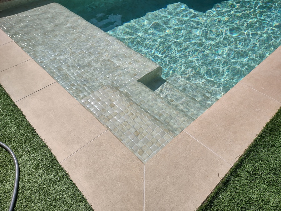 Piscina con coronación porcelánica beige y gresite Hisbalit Aqualuxe Mallorca en formato 4x4.