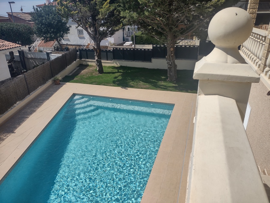 Piscina con entorno porcelánico beige y gresite PS-40 de Reviglass.