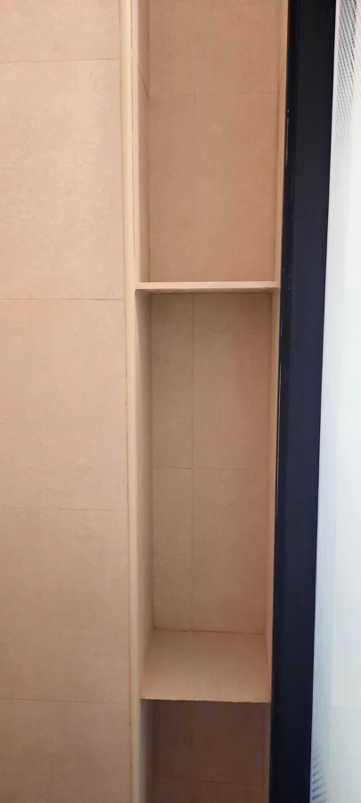 Baldas interiores hechas de obra para colocación de utensilios de ducha.