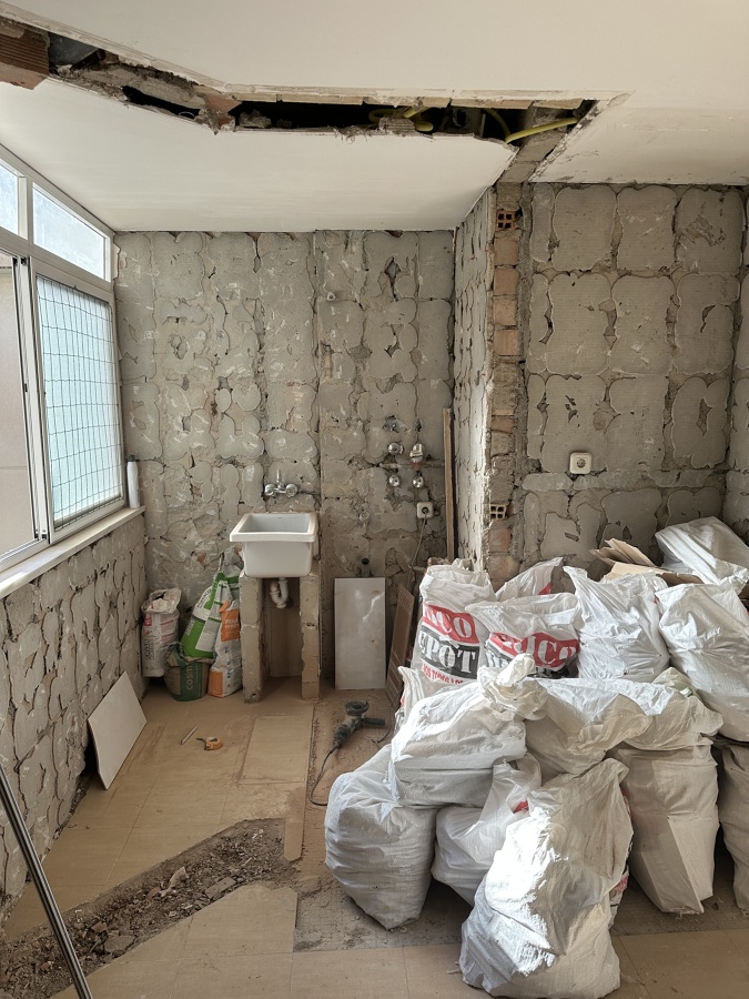 Cocina dejada diáfana pillando lavadero para hacerla más grande fontanería electricidad saneamiento ventana calefacción azulejos y suelo además de puerta