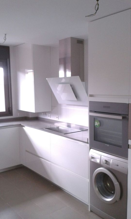 Zona de cocción, con campana en cristal blanco.