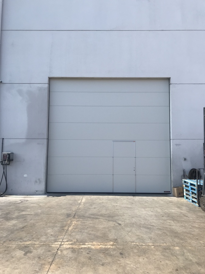 Puerta seccional industrial con peatonal incorporada Hörmann