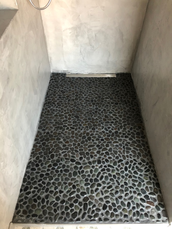SUELO DE DUCHA EN ACABADO CON PIEDRA REDONDA.