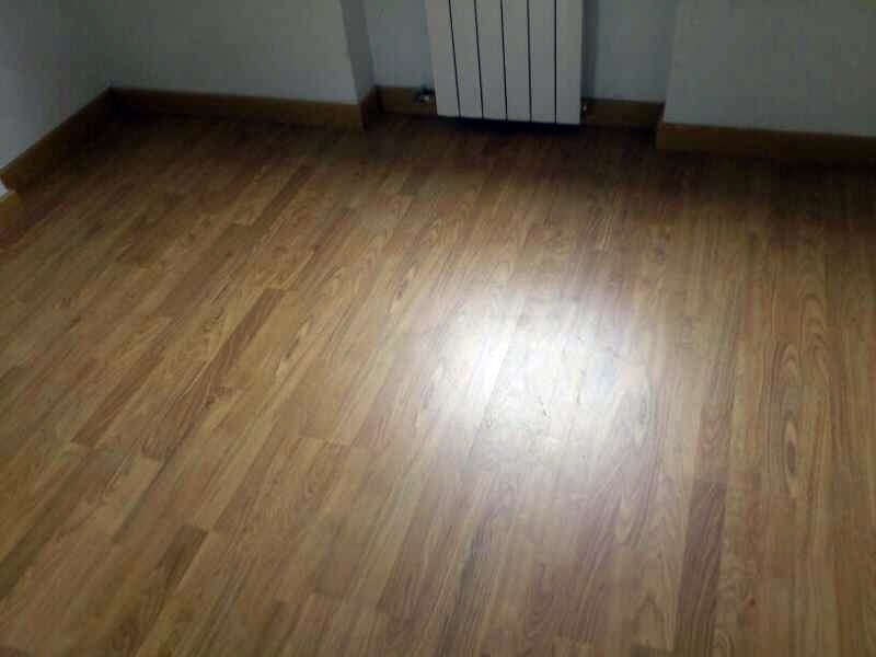 Instalación de tarima roble oscuro mate en habitación.