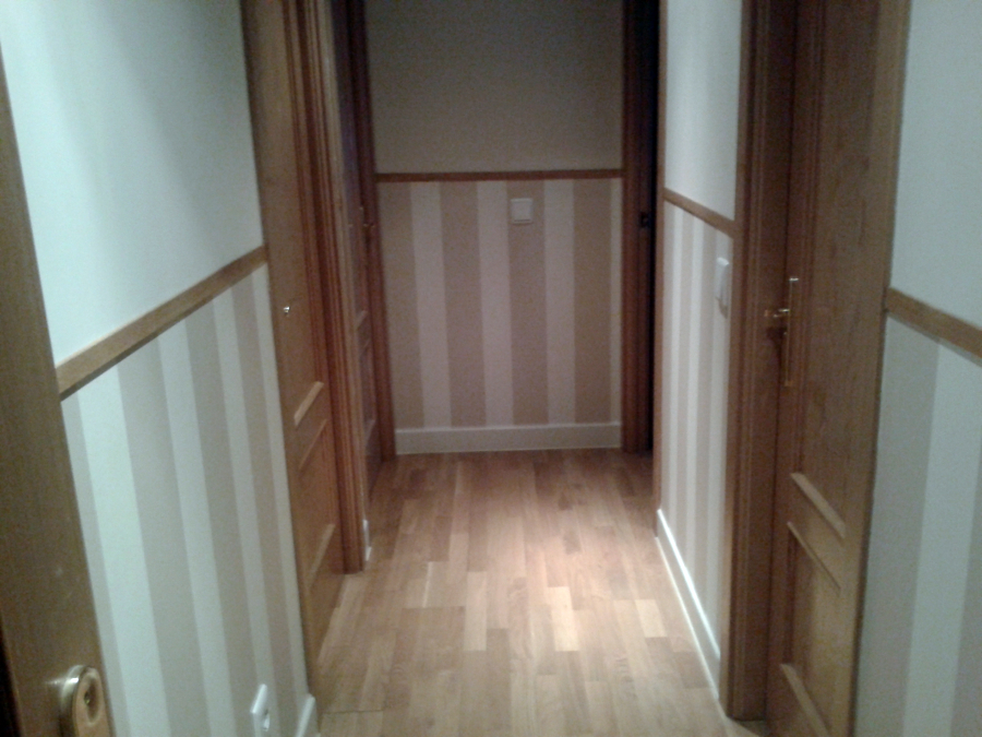 instalación de zócalo de papel pintado en pasillo