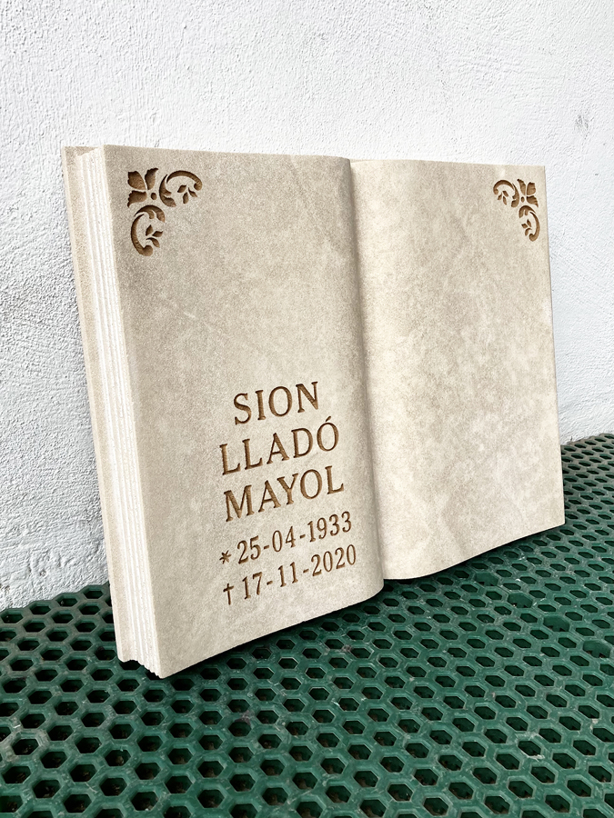 Libro de piedra natural con inscripción y motivos.