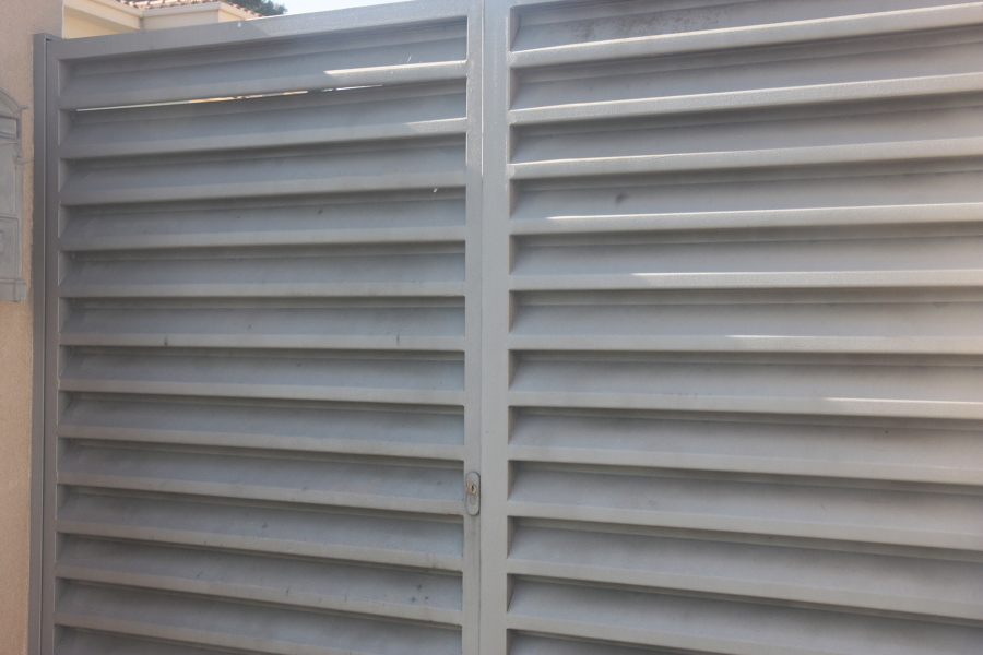 Puerta peatonal con lama veneciana color gris forja.