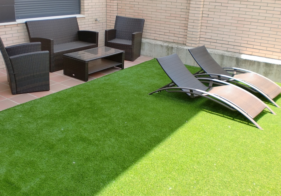 Césped sobre tierra con mobiliario de ratán