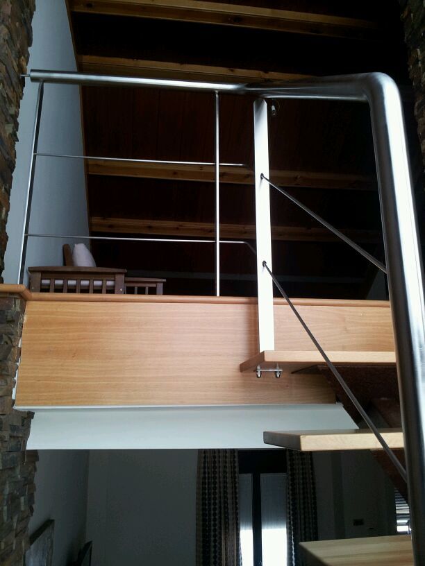 peldaños de madera con barandilla de acero inoxidable