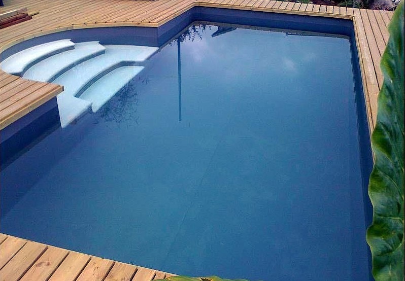 Piscina azul marino con escalera blanca antideslizante