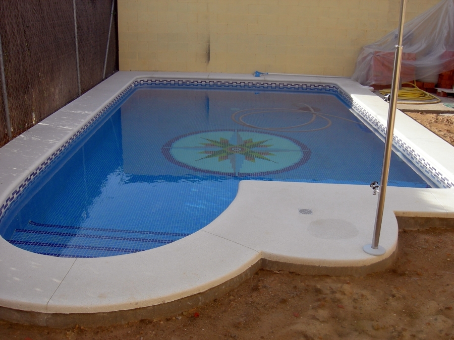 Piscina de 8*m con dibujo de la rosa de los vientos en el suelo.