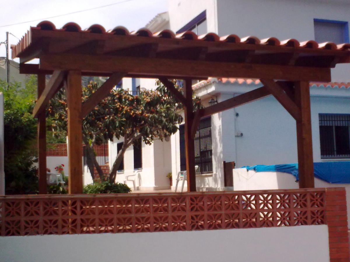 Porche de madera acabado con teja cerámica.