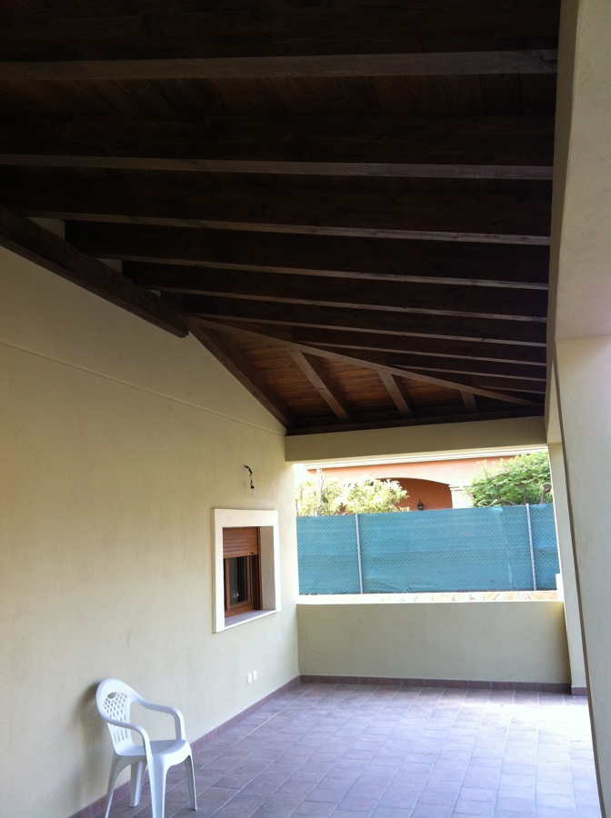 Porche de madera laminada cubierta a tres aguas.