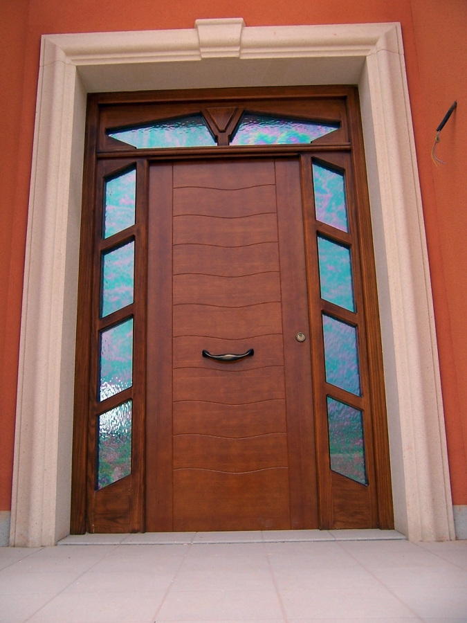 Puerta de entrada principal en pino tea tintado en color nogal claro.  