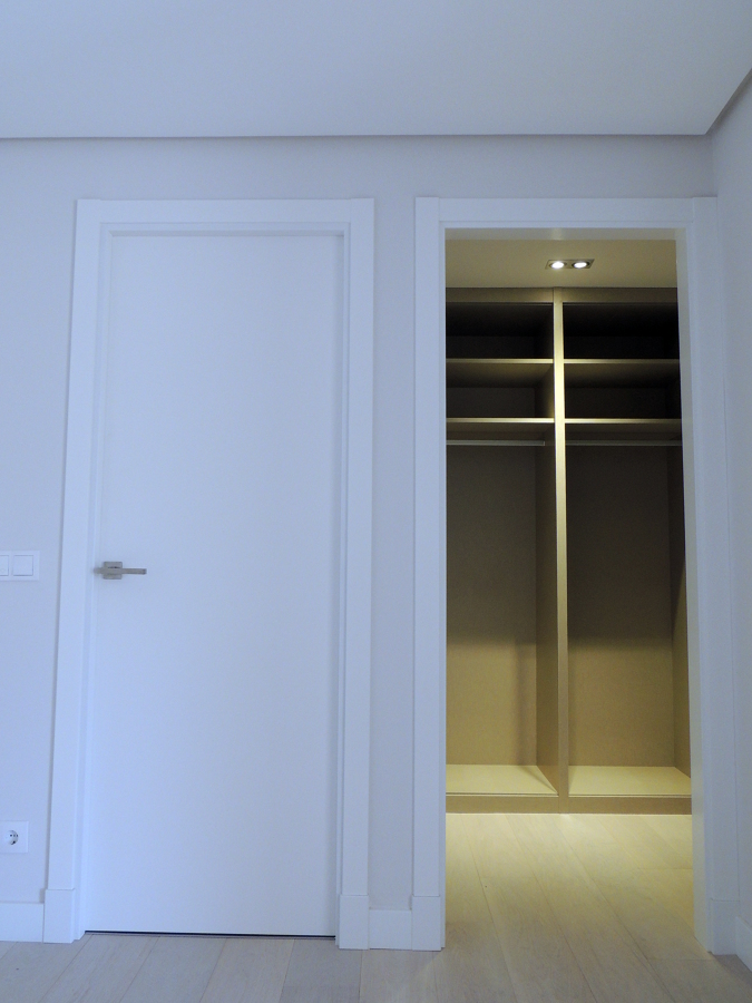 Puerta de paso lisa lacada en blanco y armario gabanero.